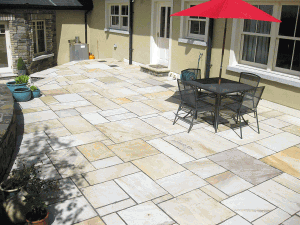 patio with multi sized and multicoloured sandstone paving slabs